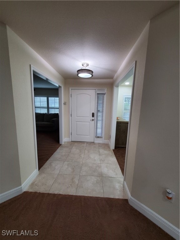 interior space featuring a textured ceiling and light tile patterned floors