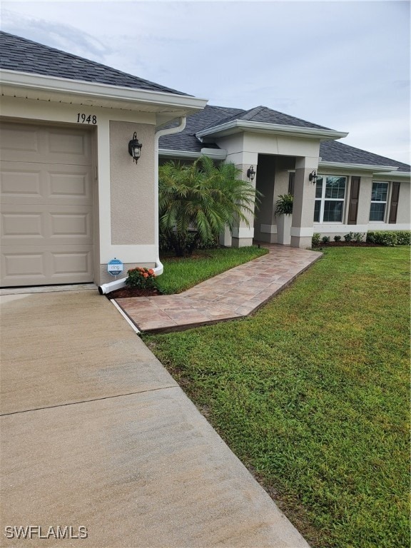 doorway to property with a yard and a garage