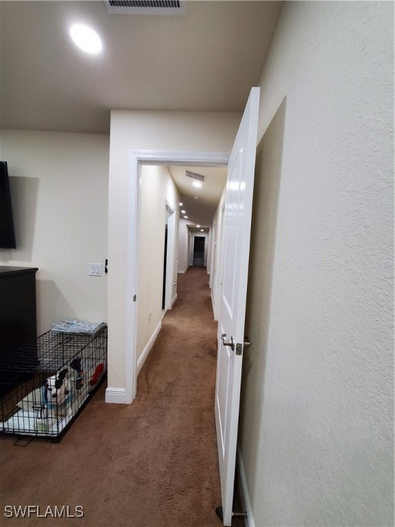 hallway with dark colored carpet