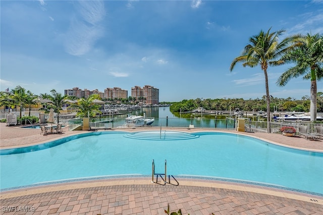 view of swimming pool featuring a water view and a patio area