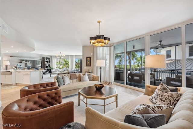 living room featuring ceiling fan with notable chandelier and plenty of natural light