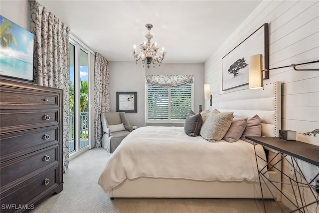 carpeted bedroom featuring a notable chandelier, wooden walls, access to exterior, and multiple windows