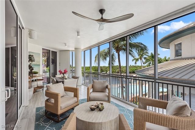 sunroom with a water view and ceiling fan