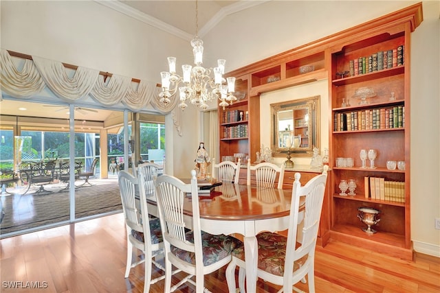 dining area featuring light hardwood / wood-style flooring, a notable chandelier, and crown molding