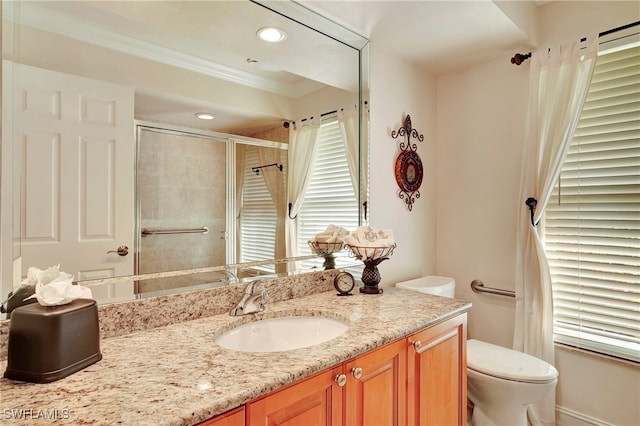 bathroom with crown molding, vanity, toilet, and an enclosed shower