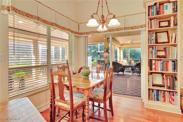 dining room with ceiling fan with notable chandelier and hardwood / wood-style flooring