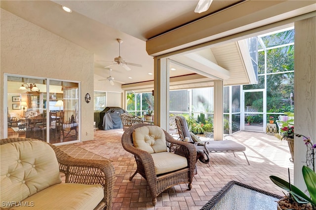 sunroom / solarium with ceiling fan, lofted ceiling, and a healthy amount of sunlight