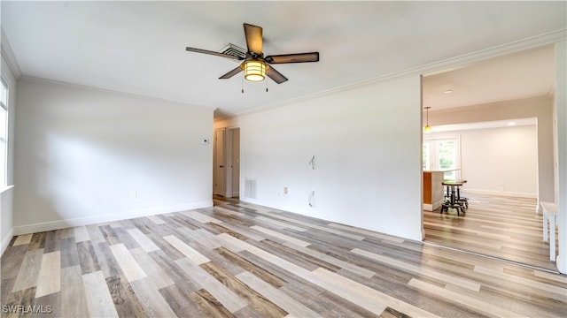 spare room featuring ceiling fan, light wood-type flooring, and crown molding