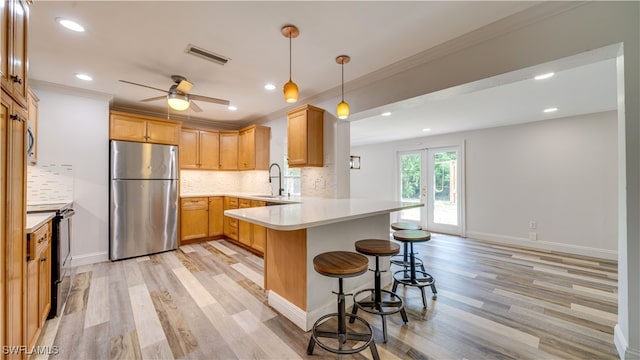 kitchen featuring black range with electric stovetop, kitchen peninsula, light hardwood / wood-style flooring, ceiling fan, and stainless steel fridge