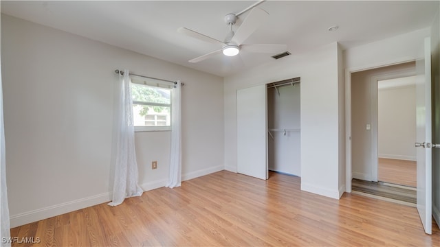 unfurnished bedroom with ceiling fan, light wood-type flooring, and a closet