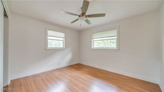 spare room with light hardwood / wood-style flooring, a wealth of natural light, ceiling fan, and crown molding