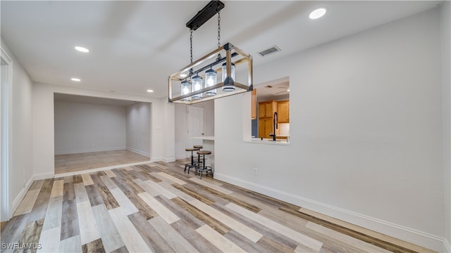 unfurnished dining area featuring light wood-type flooring