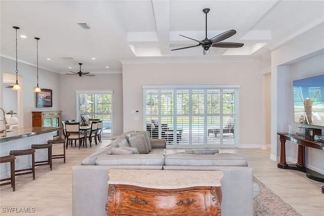 living room featuring ornamental molding, light wood-type flooring, beam ceiling, and ceiling fan