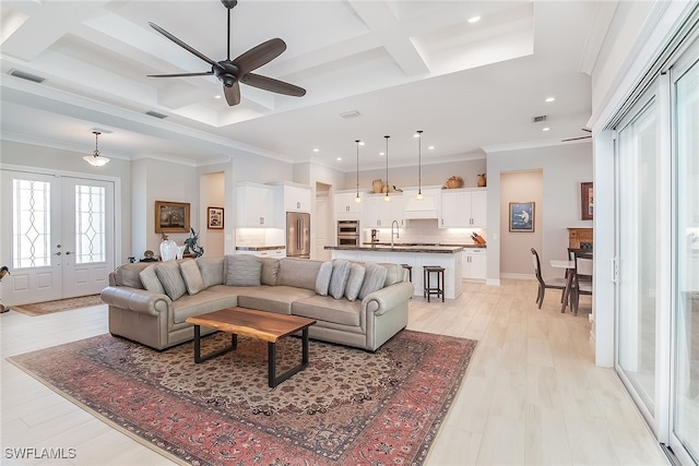 living room featuring light hardwood / wood-style floors, ornamental molding, ceiling fan, and french doors