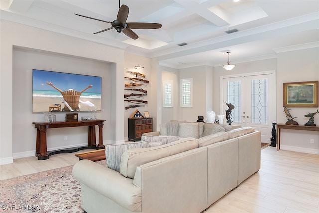 living room featuring ceiling fan, french doors, coffered ceiling, light wood-type flooring, and crown molding