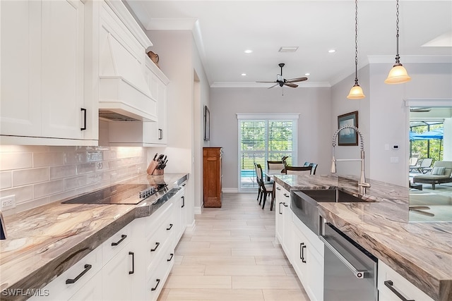 kitchen with black electric stovetop, wood counters, white cabinets, decorative light fixtures, and ceiling fan