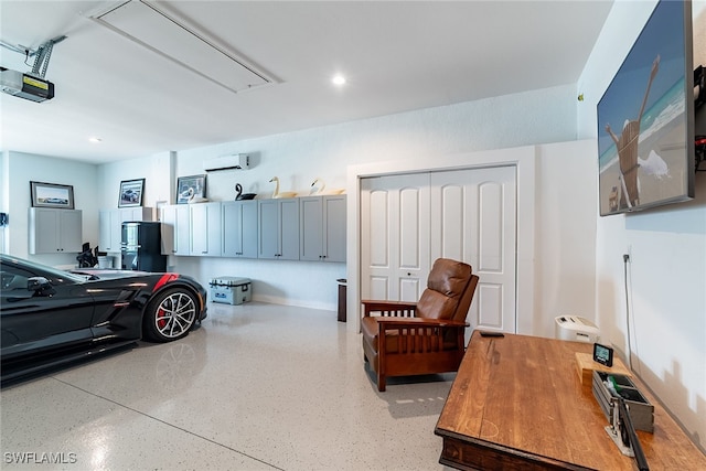 garage featuring an AC wall unit and a garage door opener