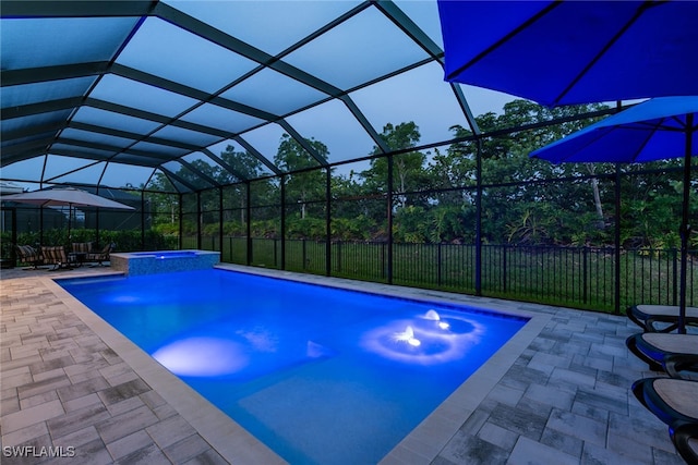 view of pool featuring a patio, glass enclosure, and an in ground hot tub