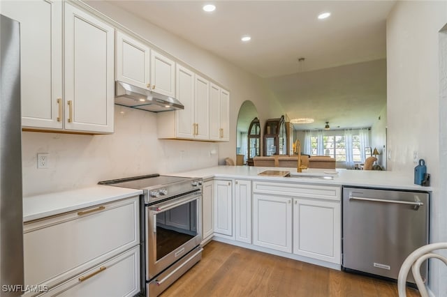 kitchen featuring appliances with stainless steel finishes, light hardwood / wood-style floors, white cabinets, kitchen peninsula, and sink