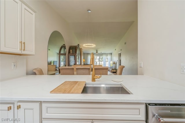 kitchen with light stone countertops, dishwasher, sink, and white cabinets