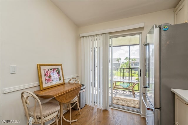 doorway featuring light hardwood / wood-style flooring and lofted ceiling