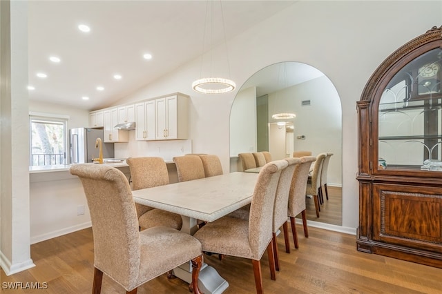 dining area with lofted ceiling and light hardwood / wood-style flooring