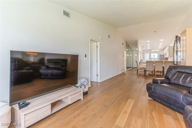 living room with light wood-type flooring and lofted ceiling