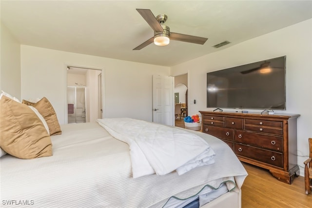 bedroom with ceiling fan, light wood-type flooring, and ensuite bathroom