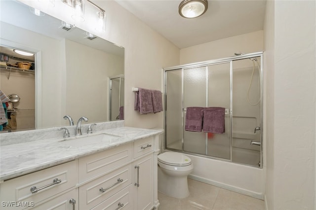 full bathroom featuring enclosed tub / shower combo, vanity, toilet, and tile patterned floors