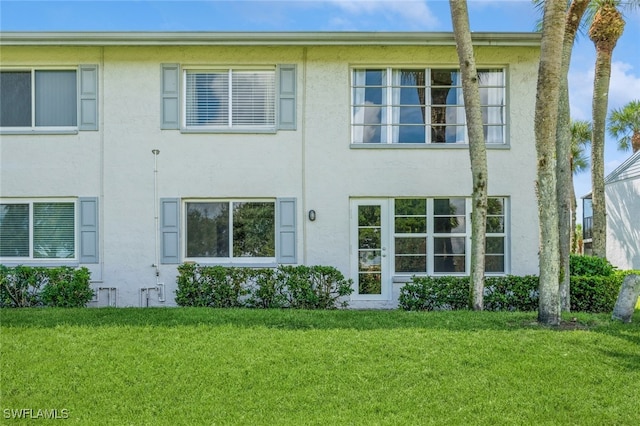 rear view of property featuring a lawn