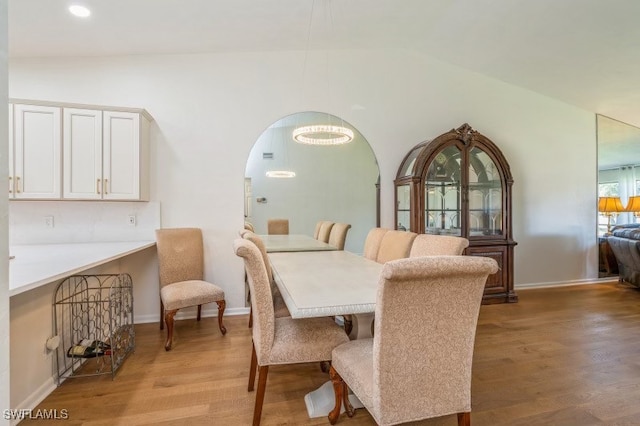 dining space with vaulted ceiling and light hardwood / wood-style floors