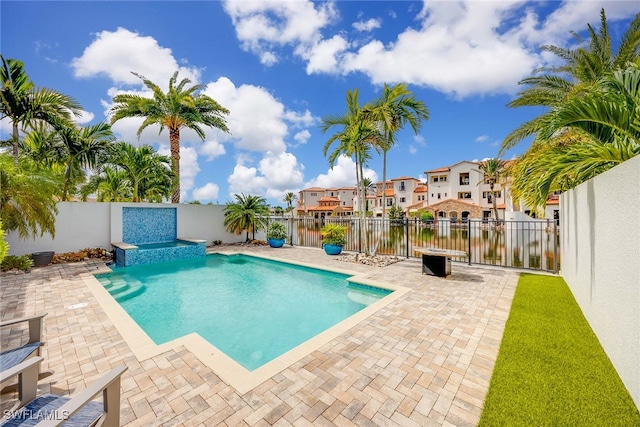 view of swimming pool featuring a patio and a water view