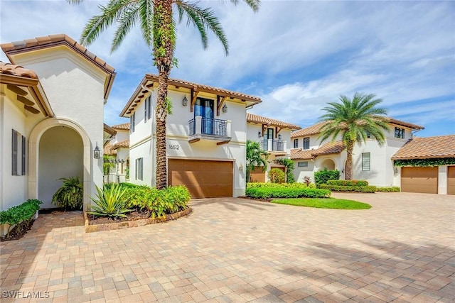 mediterranean / spanish-style house with a balcony and a garage