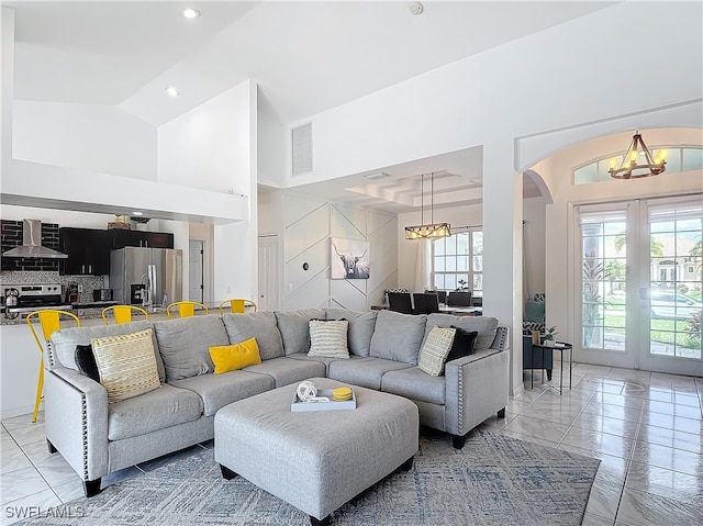 living room featuring a chandelier and high vaulted ceiling