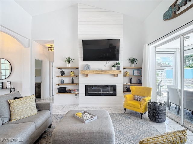 living room featuring high vaulted ceiling, a large fireplace, and light tile patterned floors