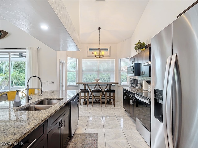 kitchen featuring an inviting chandelier, appliances with stainless steel finishes, a healthy amount of sunlight, and sink