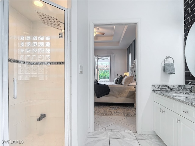 bathroom with vanity, a tray ceiling, and a shower with shower door