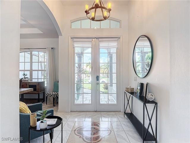 entrance foyer featuring french doors and a notable chandelier