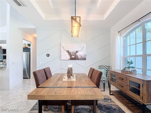 dining space with a tray ceiling