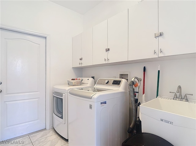 laundry area featuring washer and clothes dryer, sink, and cabinets