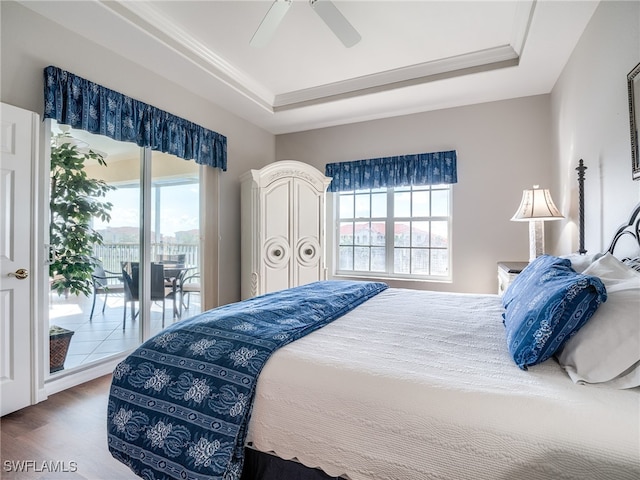 bedroom featuring multiple windows, wood-type flooring, ceiling fan, and access to exterior