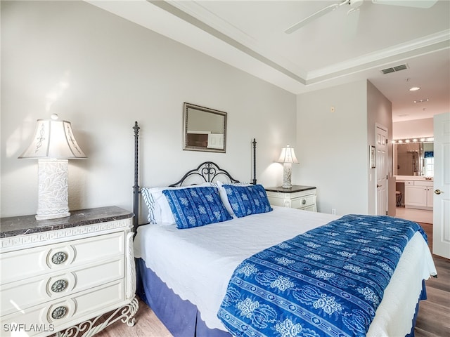 bedroom featuring wood-type flooring, ceiling fan, and ensuite bath