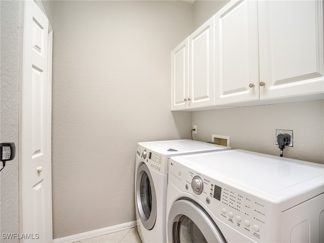 laundry area featuring cabinets, washer and clothes dryer, and light tile patterned floors