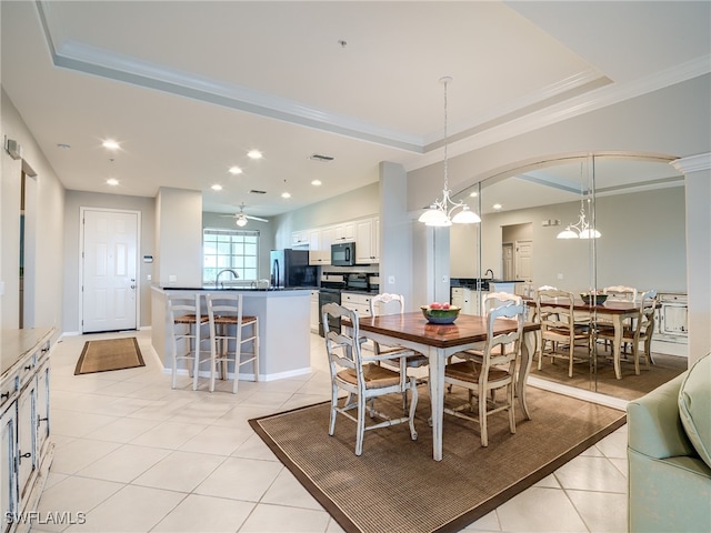 dining area with a raised ceiling, light tile patterned floors, ceiling fan, and crown molding