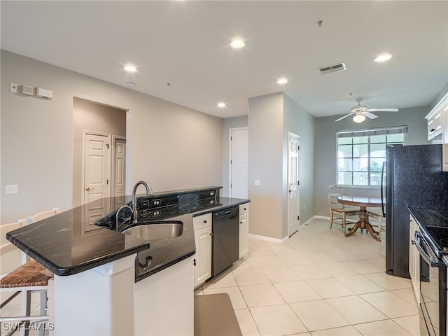 kitchen featuring dishwasher, white cabinets, sink, stainless steel range oven, and a kitchen island with sink