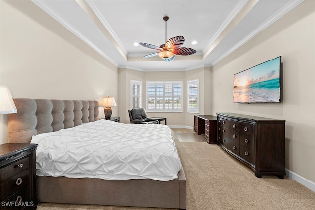 bedroom with crown molding, light carpet, a tray ceiling, and ceiling fan