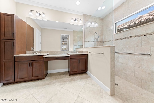 bathroom featuring vanity, ornamental molding, tiled shower, and tile patterned flooring