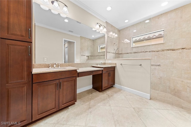 bathroom with vanity, a tile shower, crown molding, and tile patterned floors