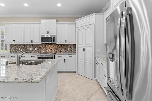 kitchen with white cabinets, light stone countertops, sink, crown molding, and stainless steel appliances