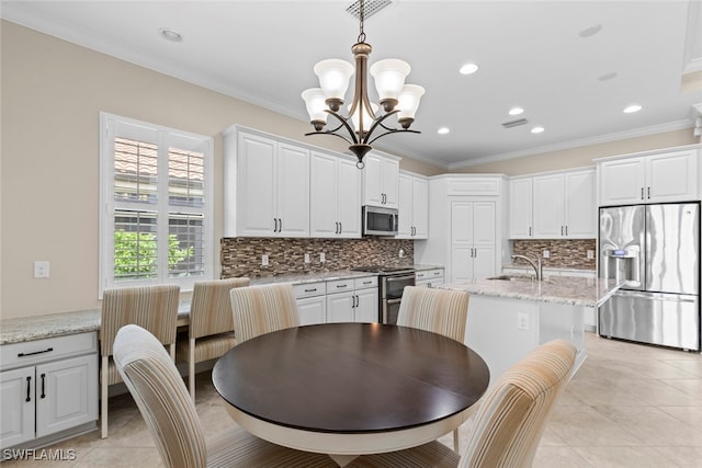 tiled dining room featuring sink, crown molding, and a chandelier